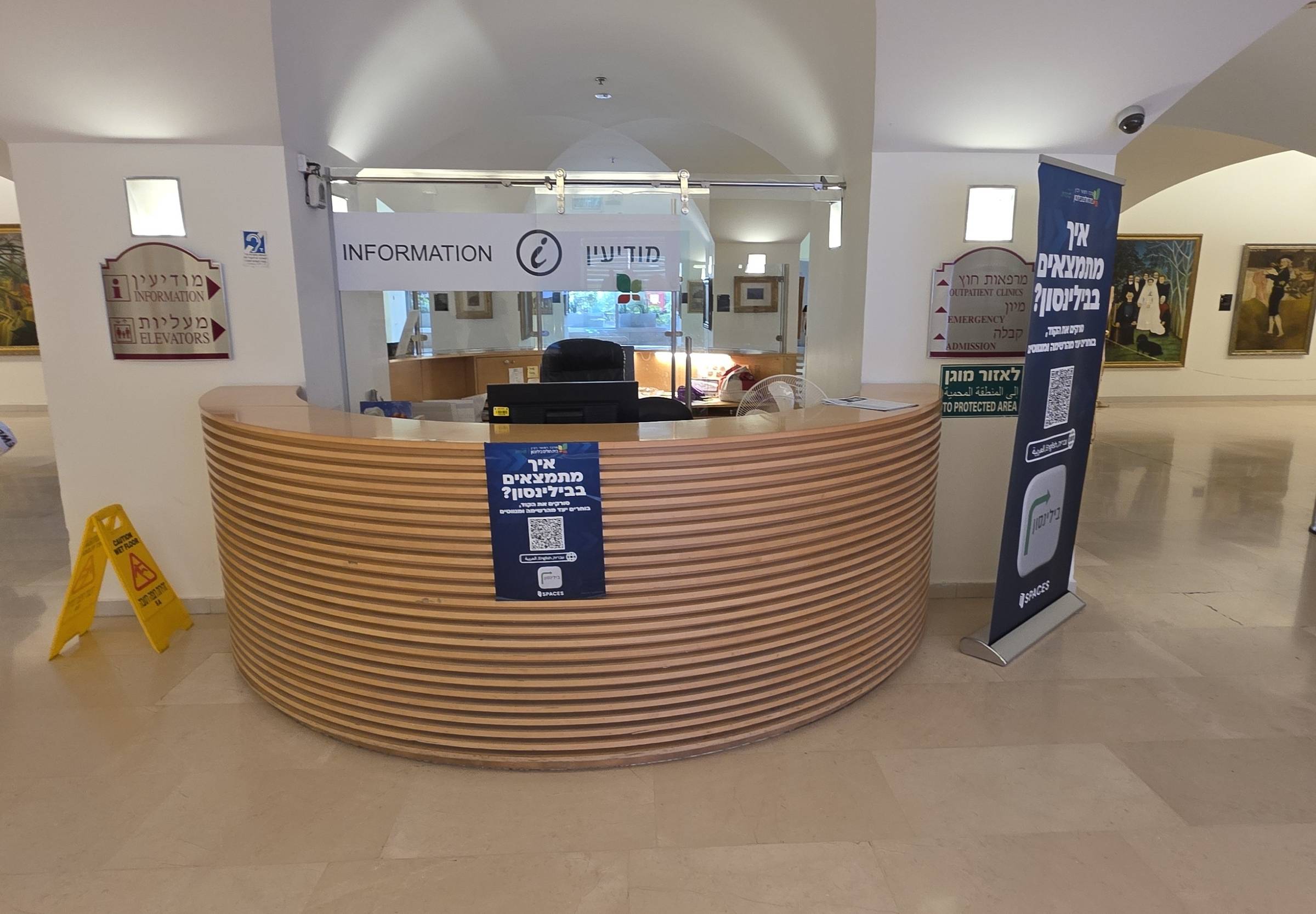 A clinic reception desk and information point under a vaulted ceiling.