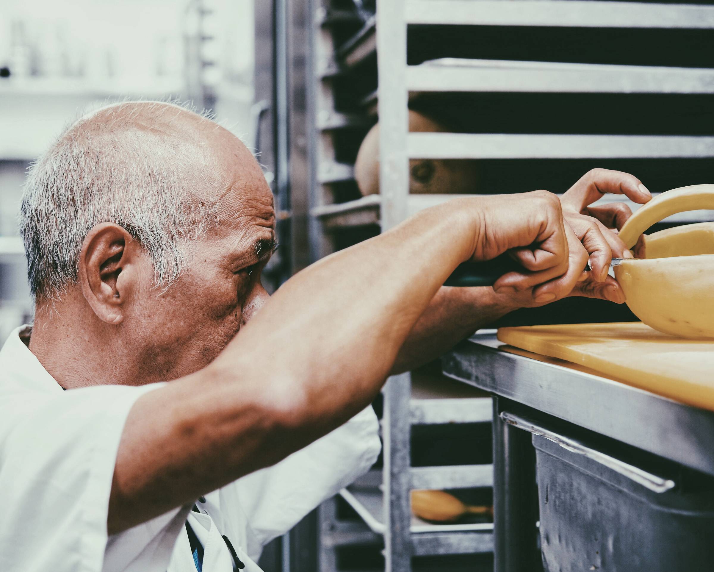 A long-serving machine operator making an adjustment to a running machine.